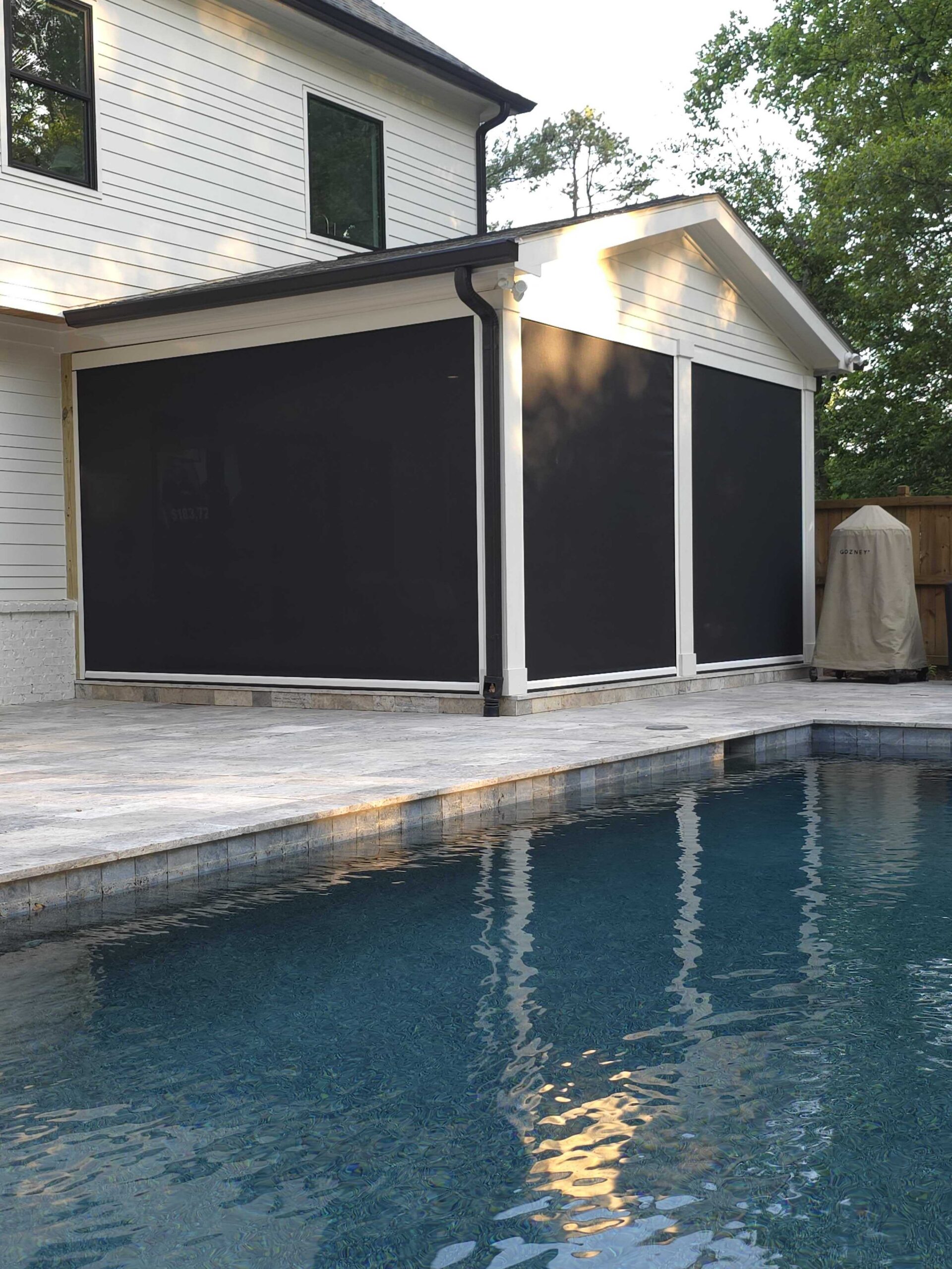 Motorized screens on a covered poolside patio