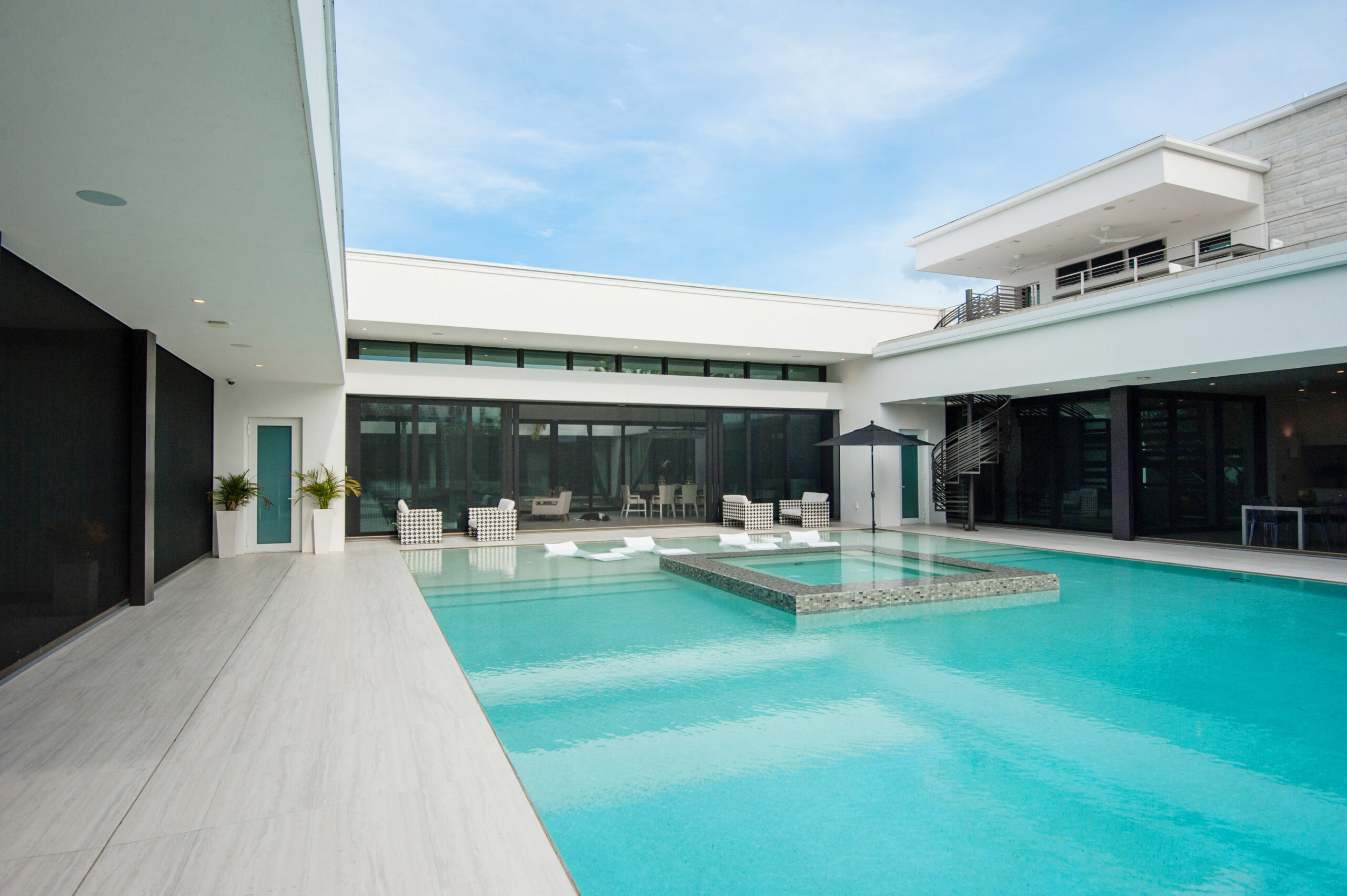 Modern home with motorized screens along a pool patio